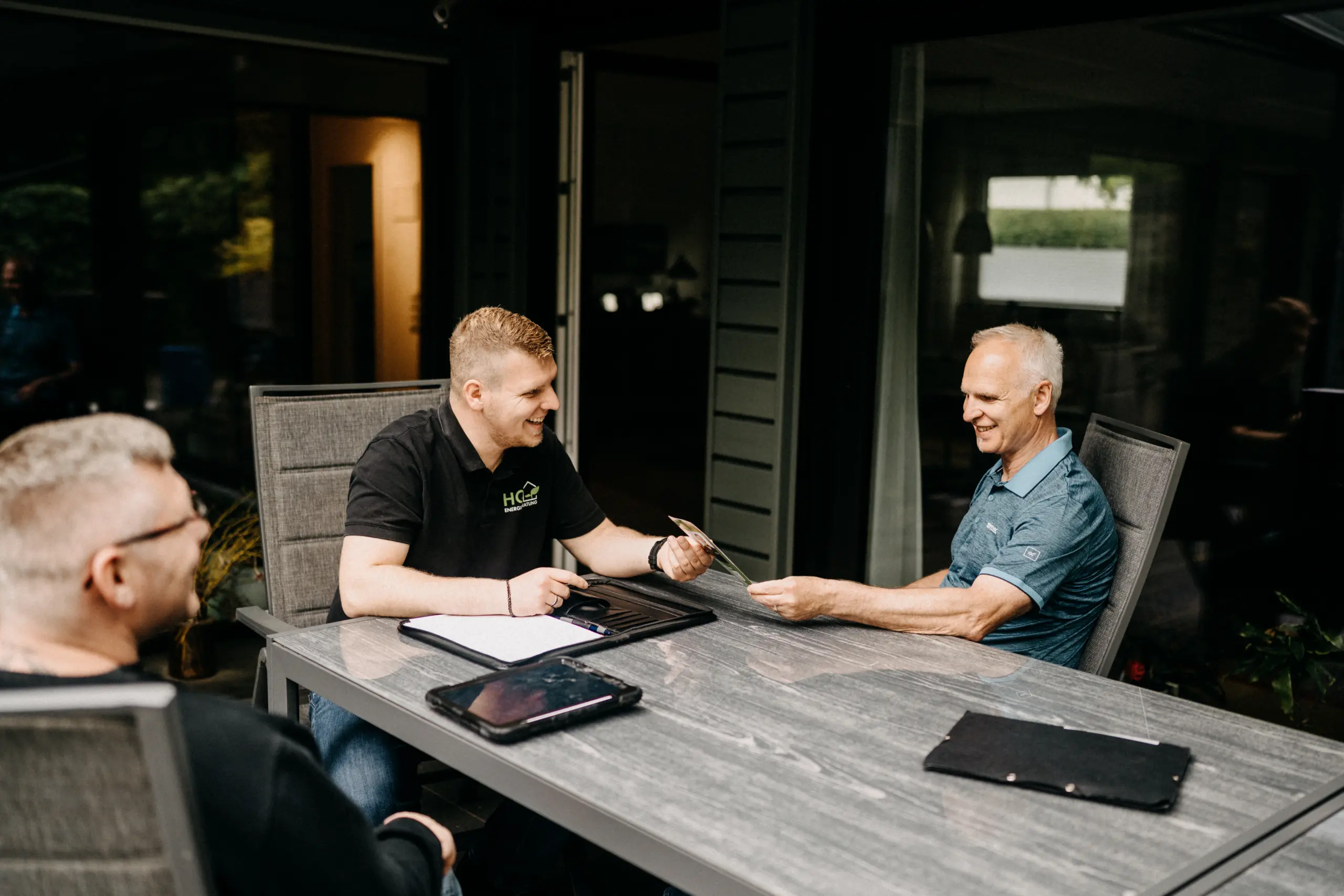 Andre und Florian Handschuh von HQ Energieberatung beraten gemeinsam einen Kunden auf dessen Terrasse – entspannte Atmosphäre beim persönlichen Beratungsgespräch