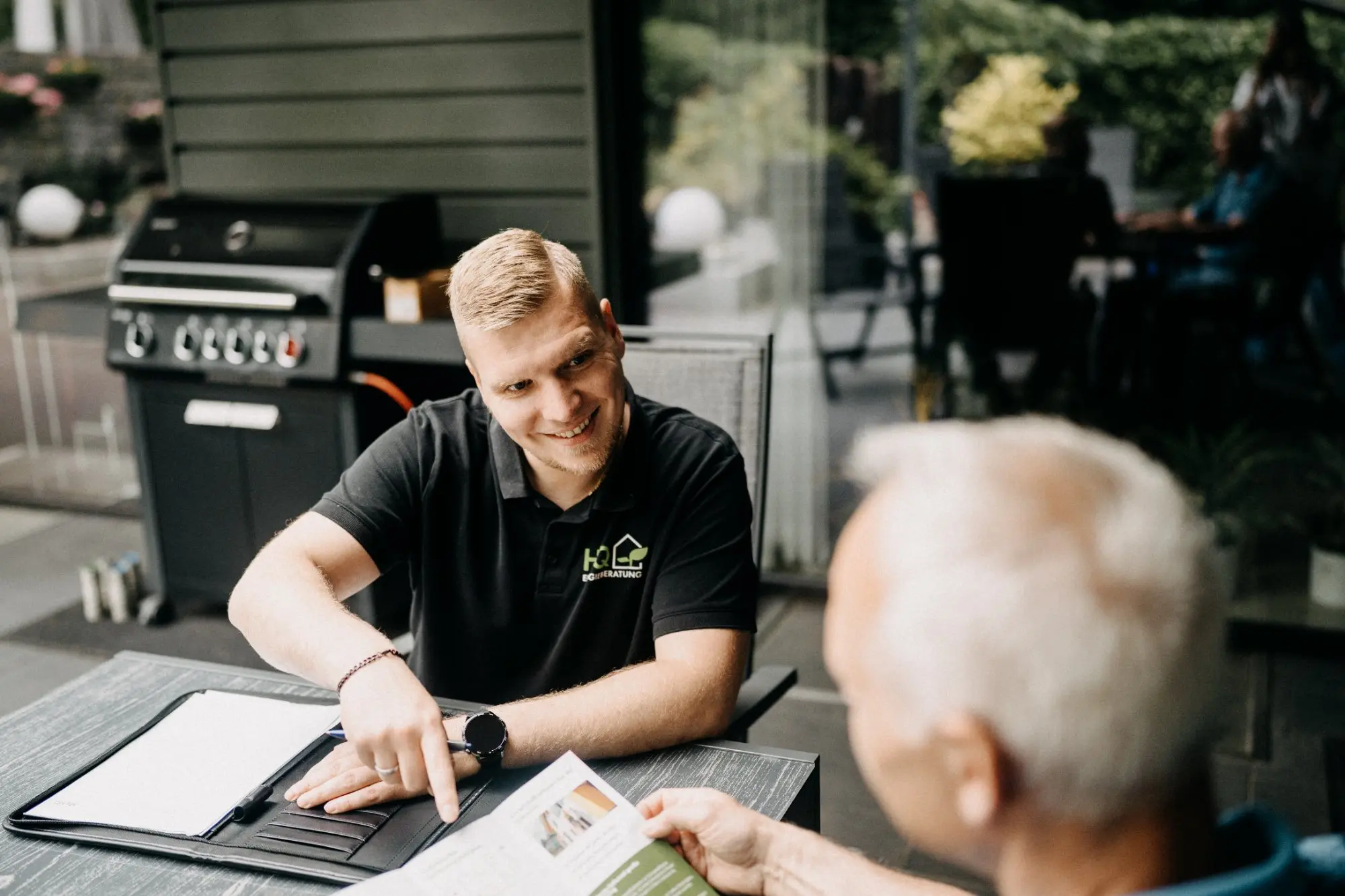 Andre Handschuh von HQ Energieberatung im lockeren Beratungsgespräch mit einem Kunden auf dessen Terrasse