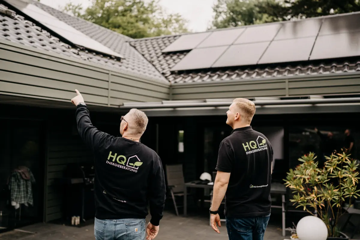 Florian und Andre Handschuh von HQ Energieberatung begutachten gemeinsam eine Solaranlage auf dem Dach eines Kundenhauses – HQ-Logo auf der Arbeitskleidung sichtbar
